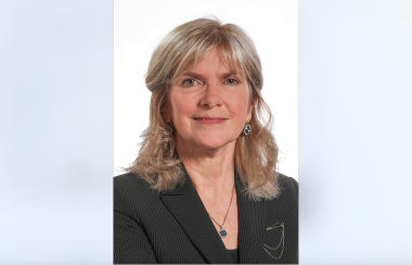 Portrait photo of Kim Adair, the Auditor General of Nova Scotia. She is smiling in a black blazer and the background is white.