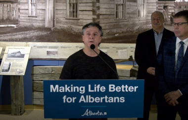 Nic Blanchet, executive director of Friends of Fish Creek Provincial Park Society standing at a podium giving a press conference about the investment.