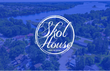 Skol house's blue cursive text-style logo is draped over a skyline view of the schoolhouse in Belwood.