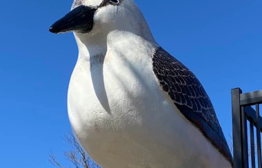 A large statue of a sandpiper outside against a blue sky