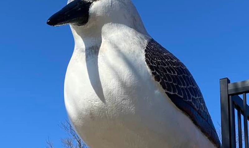 A large statue of a sandpiper outside against a blue sky