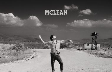 McLean sur une route de terre regardant vers le ciel