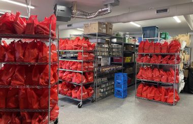Stacked selves of red bags for food donations