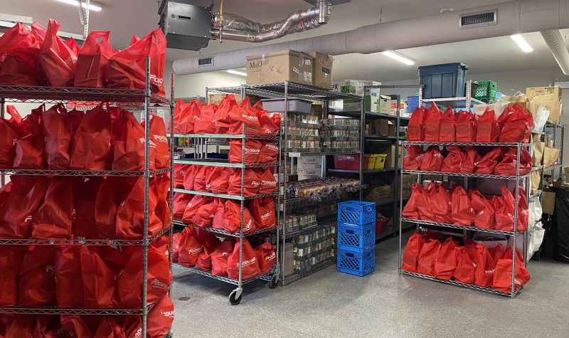 Stacked selves of red bags for food donations