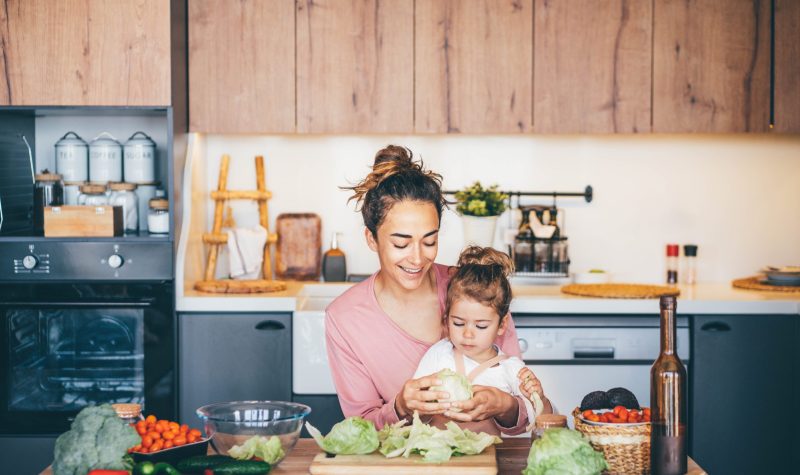 Une femme s'amusant avec sa fille tout en préparant une salade dans la cuisine. (Photo: Nicolas)