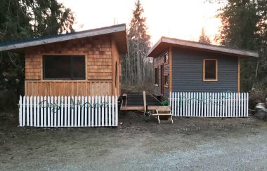 Two tiny houses are seen on Cortes Island side by side at sunset