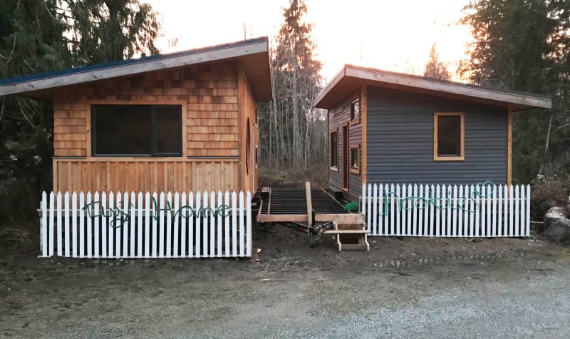 Two tiny houses are seen on Cortes Island side by side at sunset