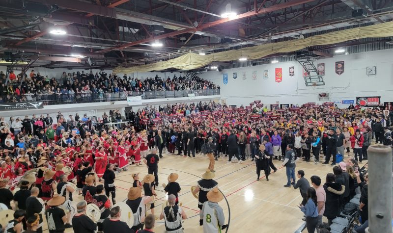 Large gathering of people in a basketball gymnasium
