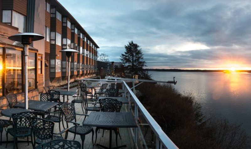 A photo of a sunset on the ocean with a hotel to the side