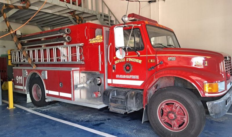 Camion de pompier rouge vue de côté à l'intérieur d'une caserne