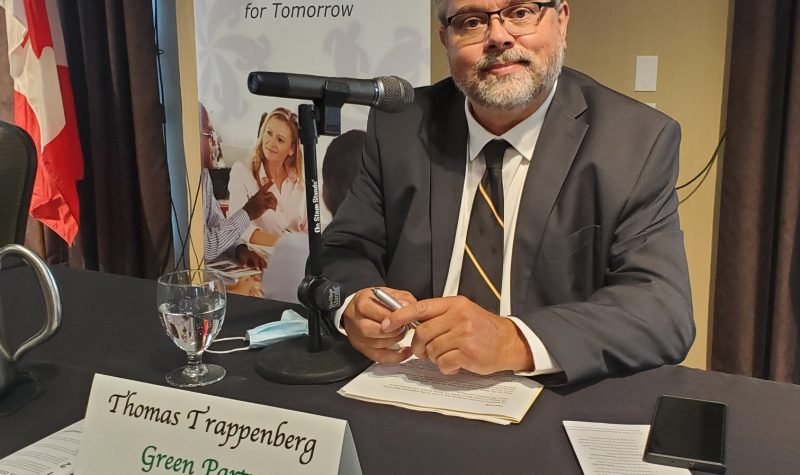 A man sits at a table with a microphone