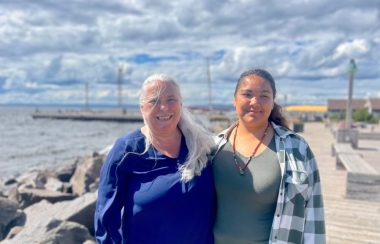 Deux femmes sur un quai au bord de l'eau.