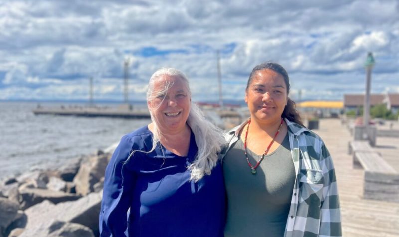 Deux femmes sur un quai au bord de l'eau.