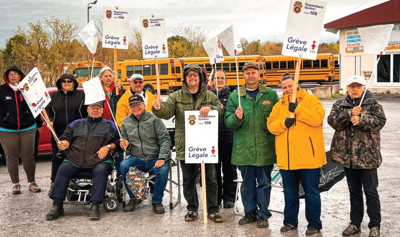Pictured are the bus drivers standing with signs in front of a number of school buses.