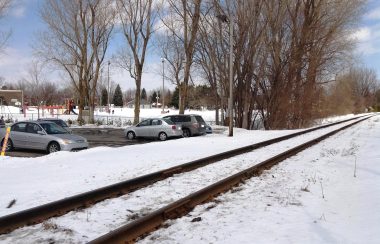 Une voie ferrée près d'un stationnement l'hiver.