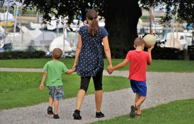Una madre con sus hijos pequeños en un parque.