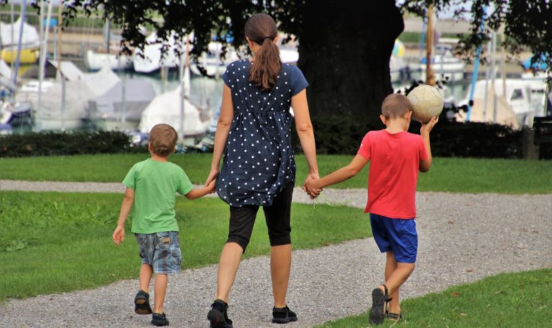 Una madre con sus hijos pequeños en un parque.