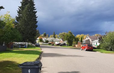 A residential street in Prince George with dramatic clouds in the sky.