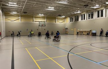 People in wheelchairs on a basketball court