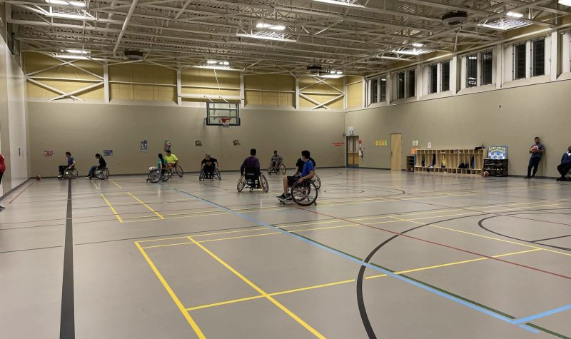People in wheelchairs on a basketball court