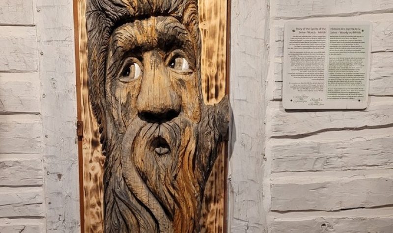 La sculpture en bois est placé contre un mur en bois banc couvrant un cadre de porte.
