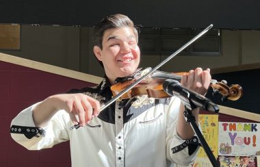 Image shows Zach Willier (17 years old) happily playing the fiddle