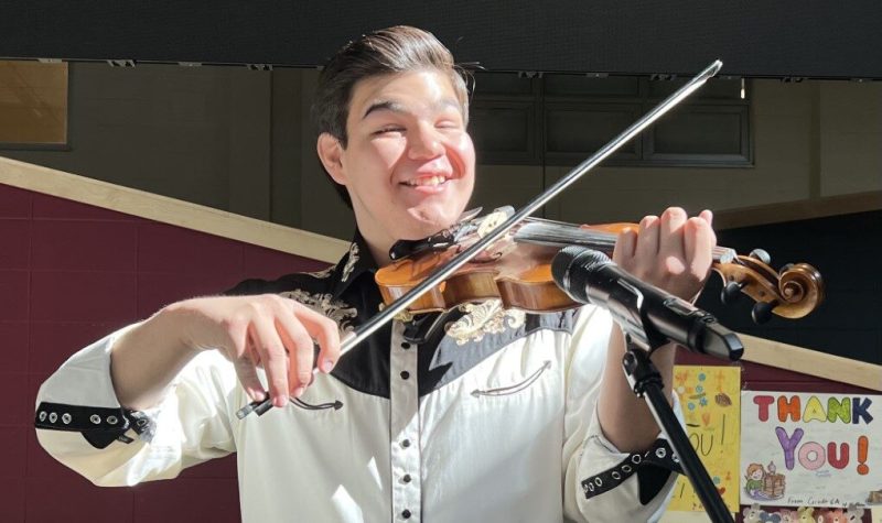 Image shows Zach Willier (17 years old) happily playing the fiddle