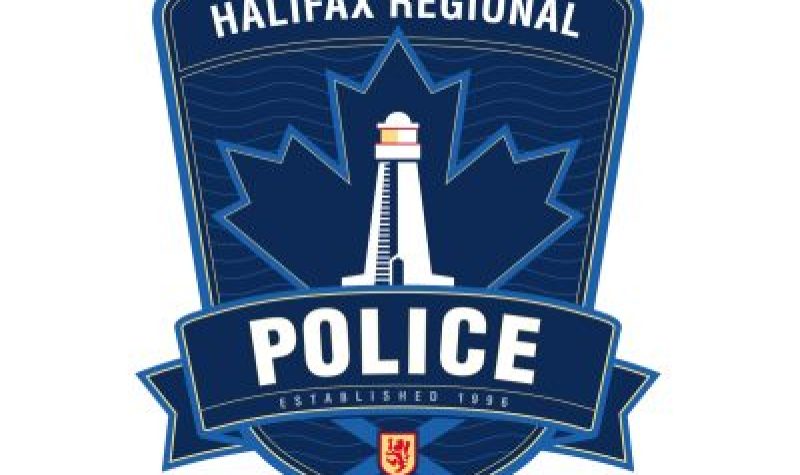 Halifax Regional Police crest in white with a white lighthouse against a blue badge with a maple leaf and Nova Scotia flag outlined on it.