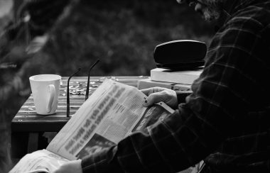 Un homme lit un journal.