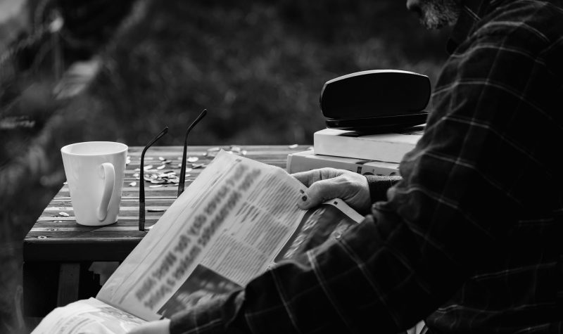 Un homme lit un journal.