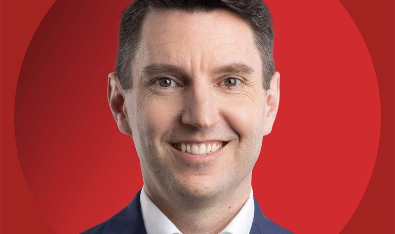 A head shot of André Fortin on a red background