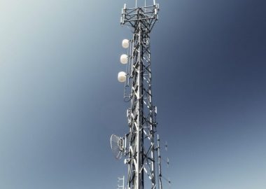 Une antenne de télécommunication entourée d'un ciel bleu.