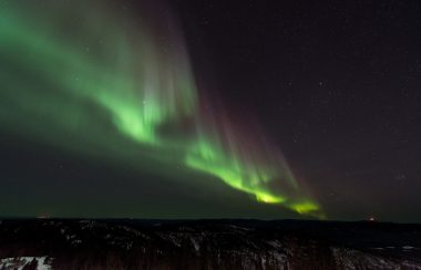 Une aurore verte et violette dans le ciel foncé.