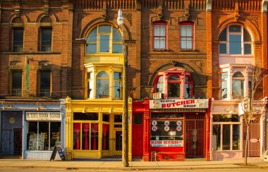 Brown, red, blue and yellow buildings on a side street in a city.