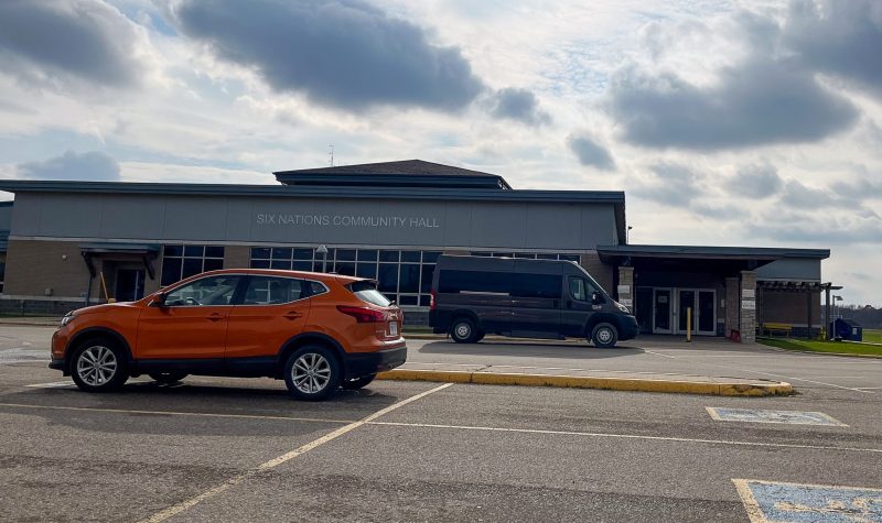 A one story building and a parking lot containing one SUV. The day is cloudy and grey.