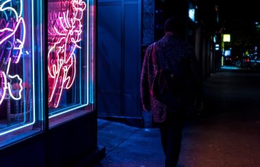 Person walking by dimly lit bar in Toronto Chinatown
