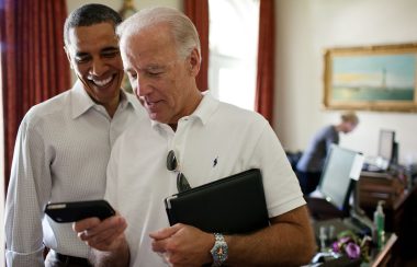 Joe Biden regarde un écran de téléphone en compagnie de Barack Obama