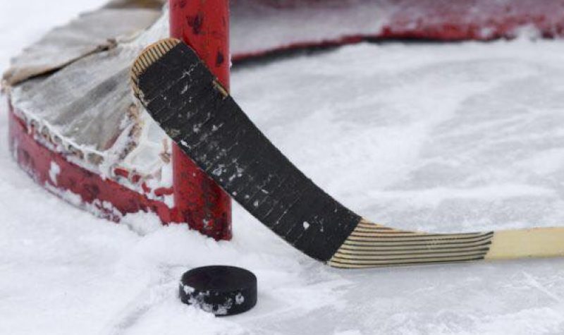 Un bâton de hockey devant un but
