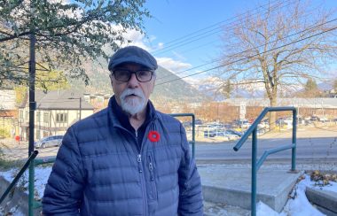 Bill Haire, branch president of the nelson branch of the royal canadian legion poses for an outdoor photo with nelson's elephant mountain in the background. Haire is wearing a red poppy on his jacket
