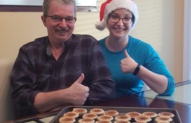 Un couple posant avec leurs biscuits de Noël