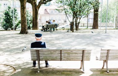 A person is sitting on a bench in the park.