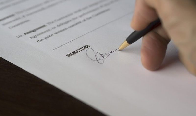 Signature d'une personne au stylo sur un feuille de papier