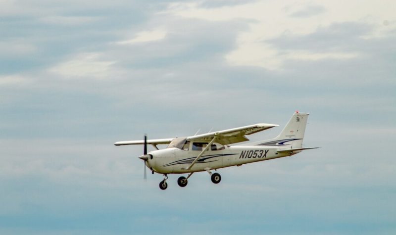 Un avion blanc de type Cessna vole dans le ciel