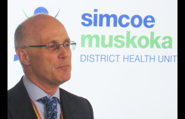 Le dr. Charles Gardner devant une pancarte du bureau de santé de Simcoe Muskoka