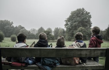 Cinq enfants assis sur un banc