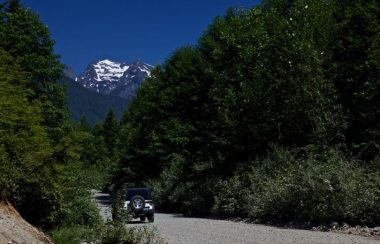 A single car travelling through an isolated Road into the forest of mission
