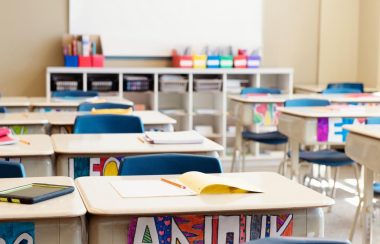 Une salle de classe lumineuse et colorée sans élèves avec des affaires sur les tables