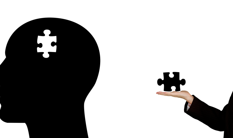 a silhouette of a head with a puzzle piece missing