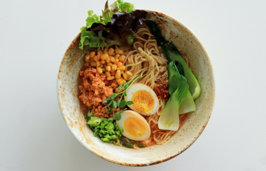 A bowl of ramen against a grey background