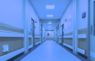Un corridor d'hôpital vide saturé d'un filtre bleuté.